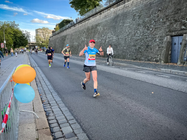 Birgit läuft ihren ersten Marathon und ist vom Ziel nicht mehr weit entfernt, als sie unterhalb der Brühl'schen Terrassen mit einem Lächeln im Gesicht entlang läuft.