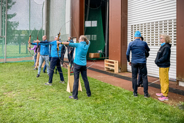 Unsere Laufgroupies spannen die Bögen und zielen auf die Scheiben beim Bogenschießen.